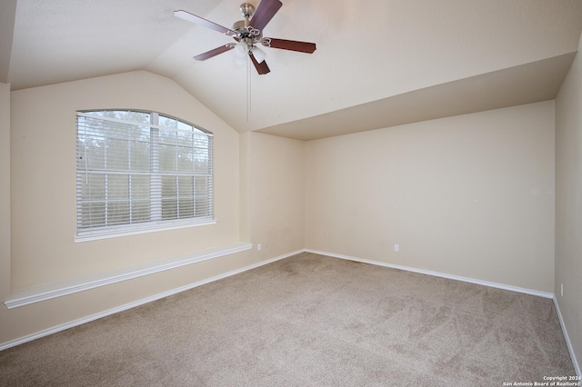 spare room with light carpet, vaulted ceiling, and ceiling fan