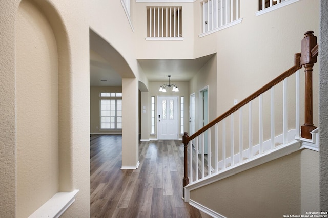 entryway featuring hardwood / wood-style floors, a high ceiling, and an inviting chandelier