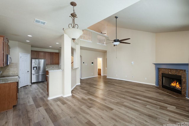 unfurnished living room featuring hardwood / wood-style flooring, ceiling fan, and a fireplace