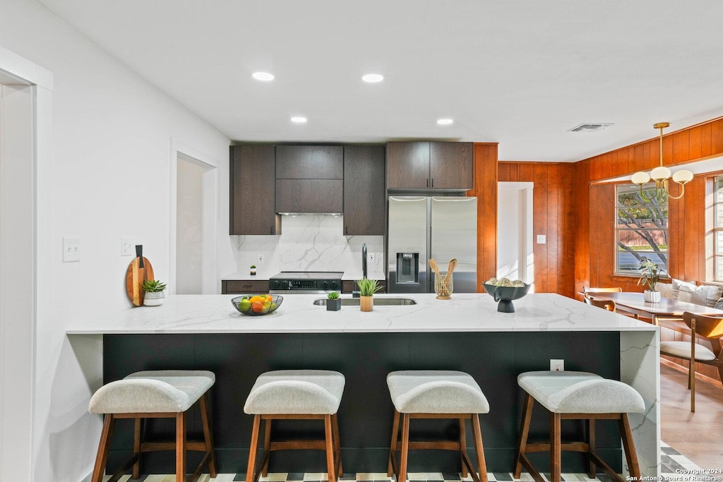 kitchen featuring sink, stainless steel appliances, a kitchen breakfast bar, tasteful backsplash, and kitchen peninsula