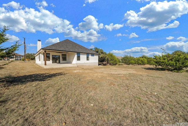 rear view of house featuring a yard and a patio area