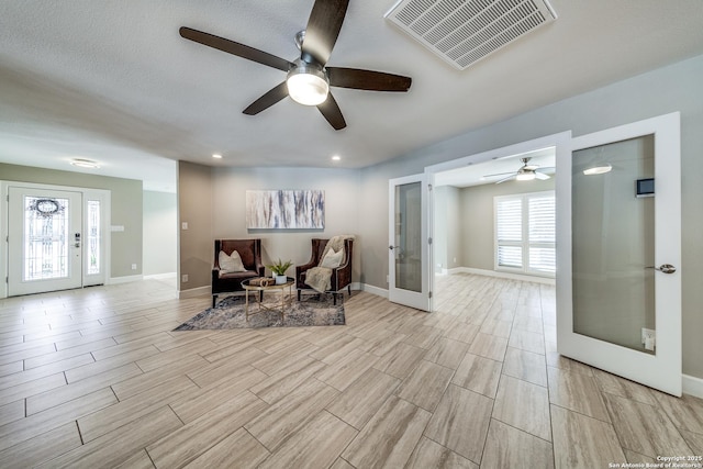 sitting room featuring french doors and ceiling fan