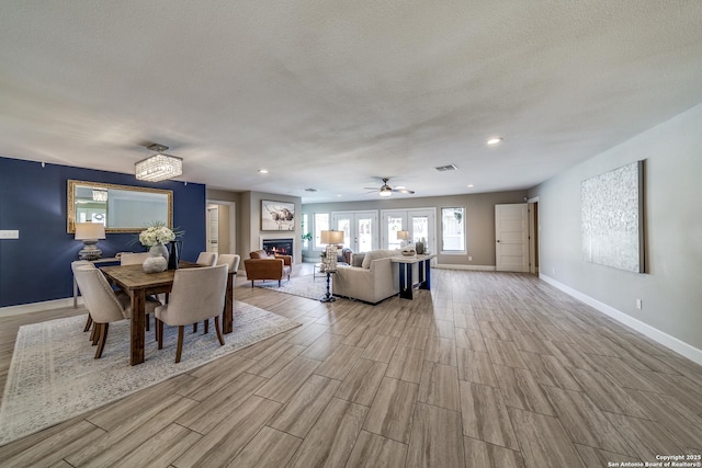 unfurnished dining area featuring ceiling fan with notable chandelier and a textured ceiling