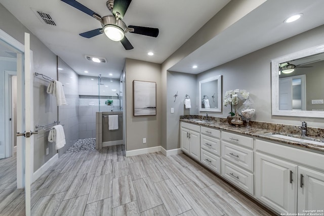 bathroom featuring tiled shower and vanity