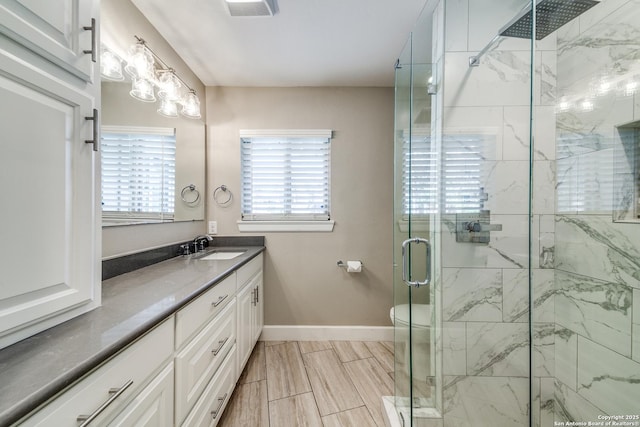 bathroom with vanity, toilet, and a shower with door