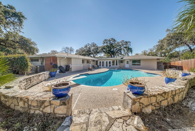 view of pool with cooling unit and a patio area