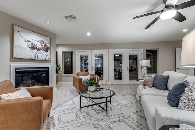 living room with french doors, light hardwood / wood-style floors, and ceiling fan