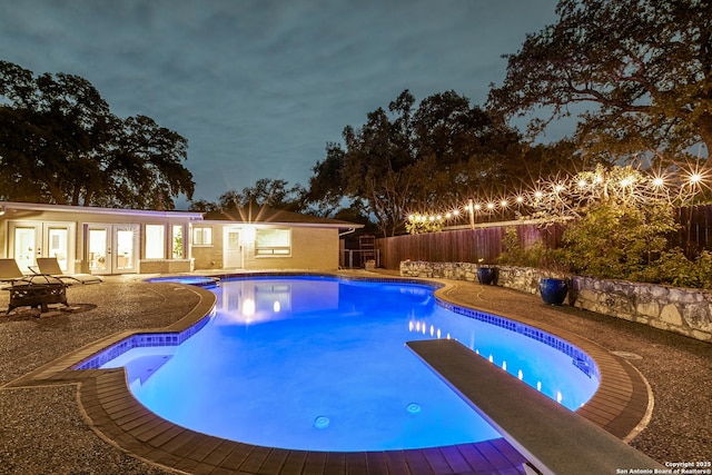 view of swimming pool with a patio and a diving board