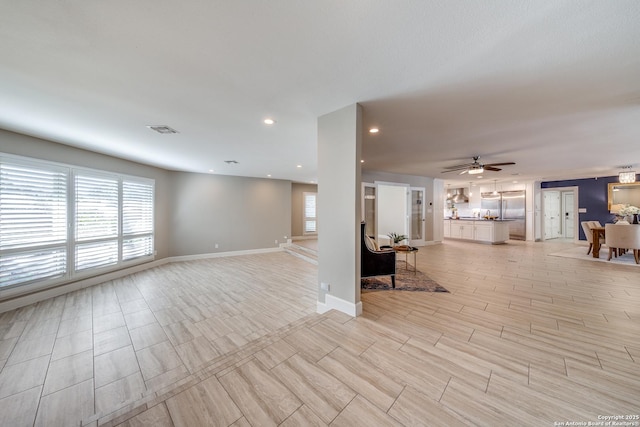 unfurnished living room with ceiling fan