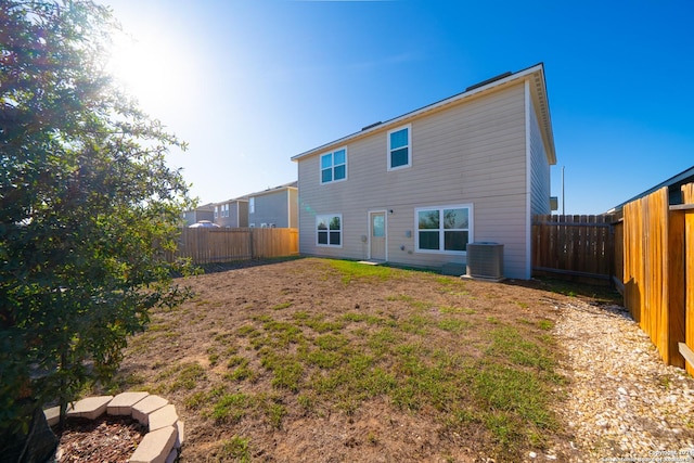 back of property featuring central AC and an outdoor fire pit