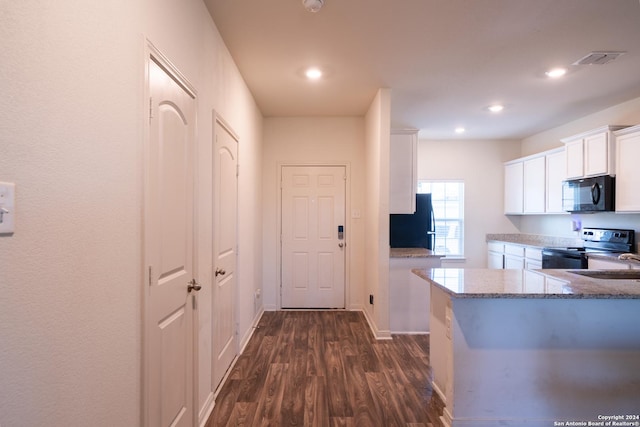 kitchen featuring dark wood-type flooring, white cabinets, light stone counters, and black appliances