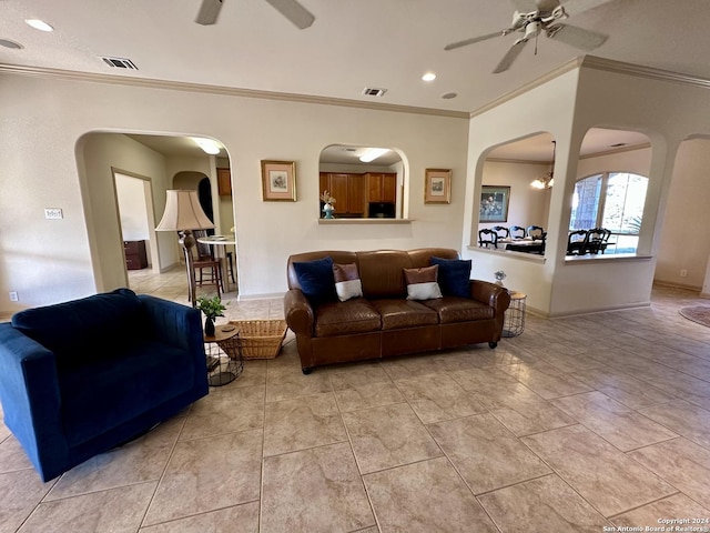 living room featuring ceiling fan with notable chandelier, light tile patterned floors, and crown molding