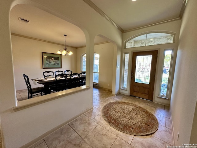 foyer featuring light tile patterned floors, a chandelier, and ornamental molding