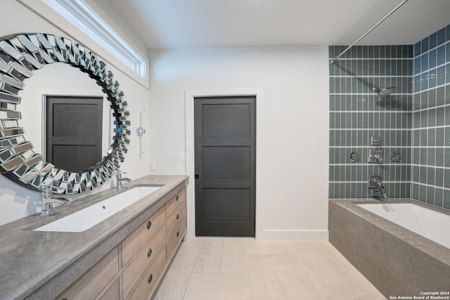 bathroom with tile patterned floors, vanity, and tiled shower / bath combo