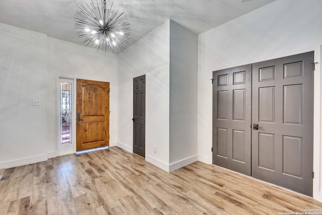 entrance foyer featuring light hardwood / wood-style floors and a notable chandelier