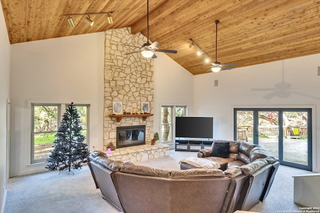 living room with a fireplace, light carpet, track lighting, and high vaulted ceiling