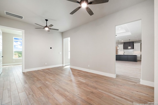 spare room with ceiling fan and light wood-type flooring