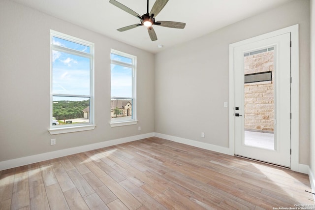 spare room with ceiling fan, a healthy amount of sunlight, and light wood-type flooring