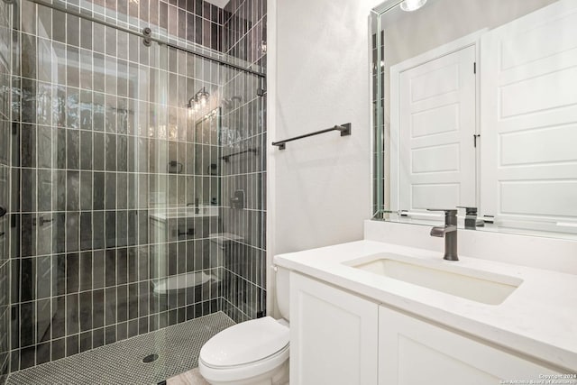 bathroom featuring vanity, toilet, and an enclosed shower