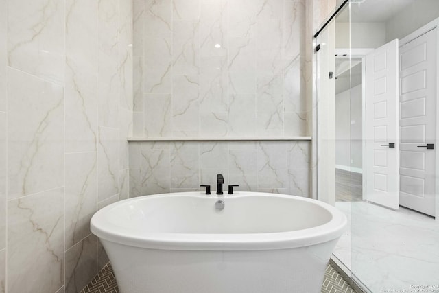 bathroom with a bathing tub and tile walls