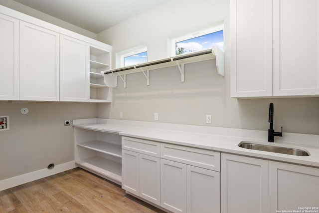 laundry area featuring sink, cabinets, electric dryer hookup, light hardwood / wood-style flooring, and hookup for a washing machine