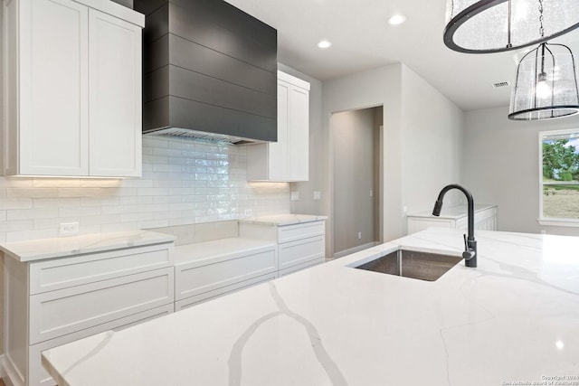 kitchen featuring white cabinetry, sink, and hanging light fixtures