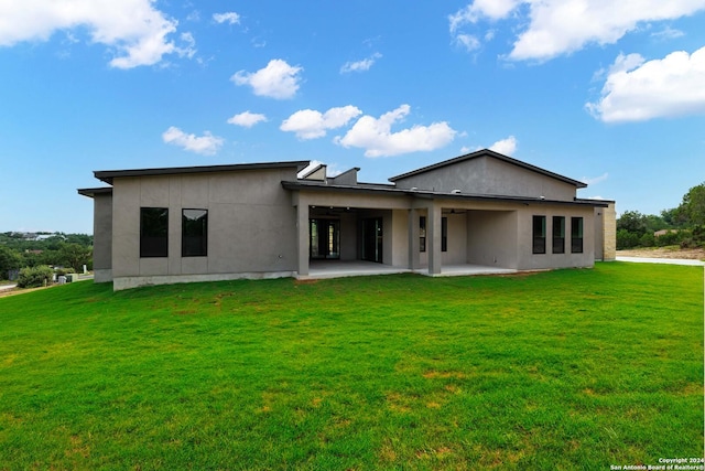 rear view of property with a yard and a patio