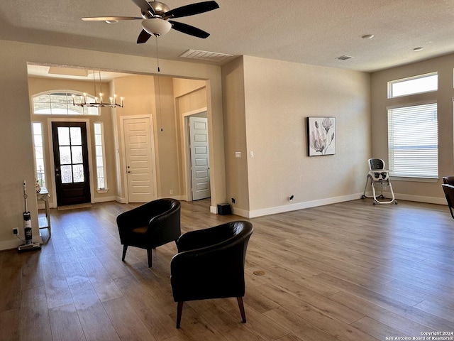 foyer featuring a textured ceiling, ceiling fan with notable chandelier, and hardwood / wood-style flooring