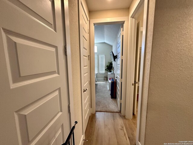 hallway featuring a textured ceiling and light hardwood / wood-style floors