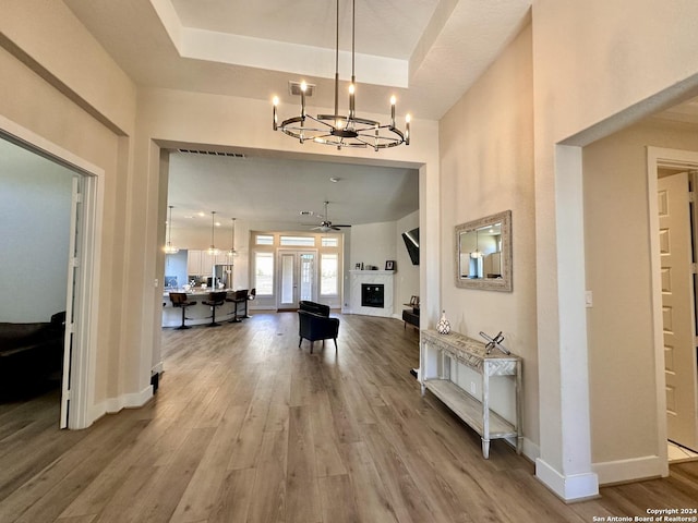 entryway featuring ceiling fan with notable chandelier and wood-type flooring