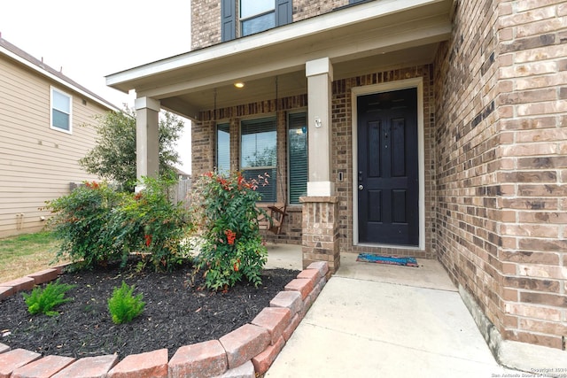 view of exterior entry featuring covered porch