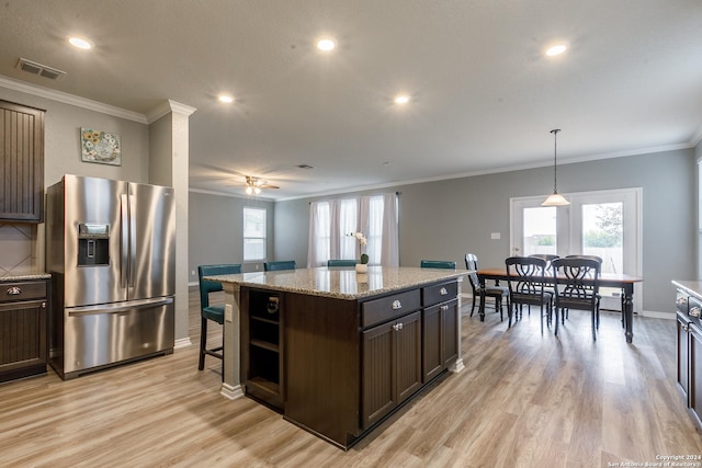 kitchen with a center island, stainless steel fridge, pendant lighting, dark brown cabinets, and light wood-type flooring