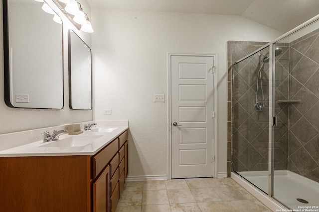 bathroom featuring tile patterned flooring, vanity, a shower with door, and lofted ceiling