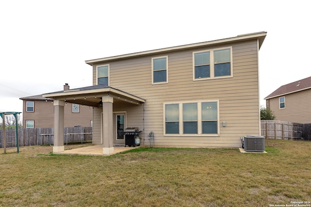 rear view of house with a lawn, a patio area, and central air condition unit