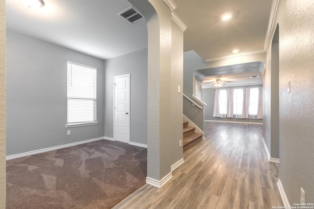 foyer entrance featuring dark hardwood / wood-style flooring, plenty of natural light, ornamental molding, and ceiling fan