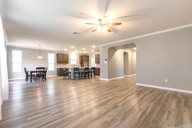 living room featuring ceiling fan, wood-type flooring, and ornamental molding