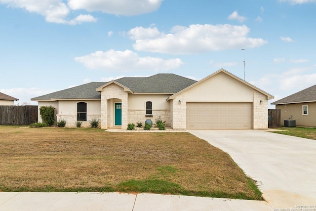 view of front of home featuring a front yard, central AC, and a garage