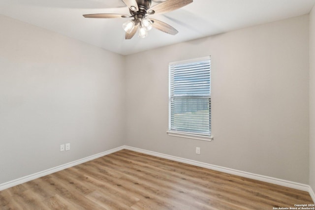 empty room featuring plenty of natural light, ceiling fan, and wood-type flooring