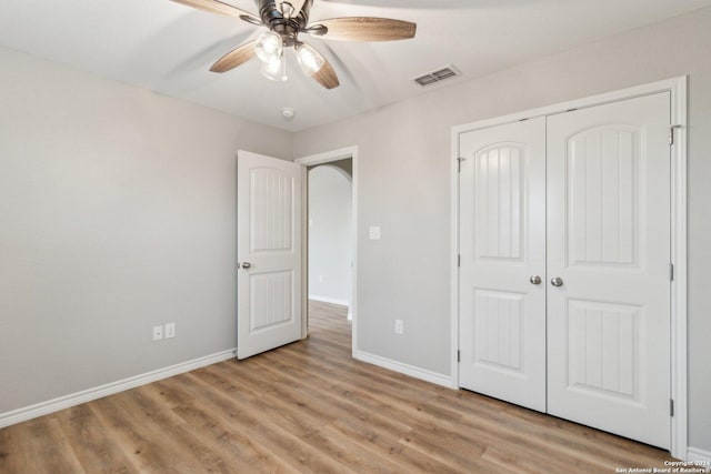 unfurnished bedroom with ceiling fan, light hardwood / wood-style flooring, and a closet