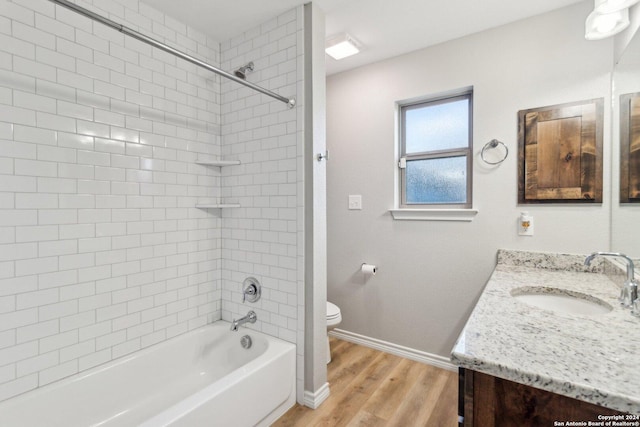 full bathroom with hardwood / wood-style floors, vanity, toilet, and tiled shower / bath