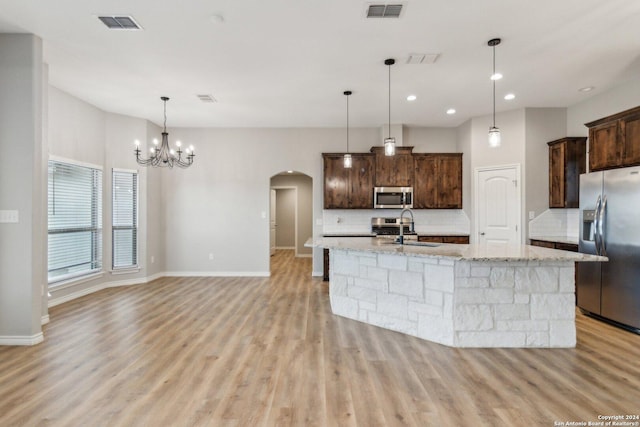 kitchen featuring decorative backsplash, sink, light stone countertops, and stainless steel appliances