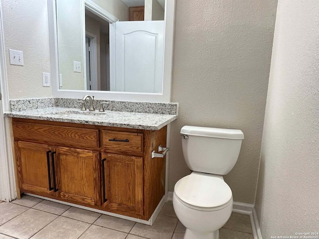 bathroom featuring toilet, vanity, and tile patterned floors