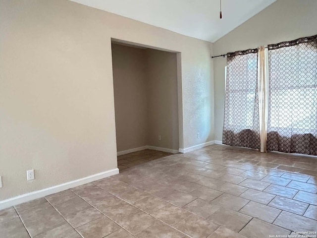 empty room with ceiling fan and lofted ceiling