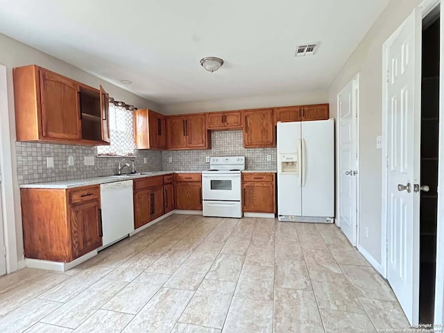 kitchen featuring white appliances, tasteful backsplash, and sink