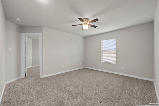 spare room featuring carpet flooring, ceiling fan, and a textured ceiling