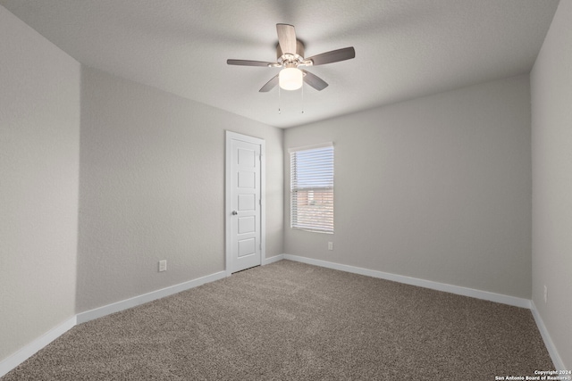 unfurnished room featuring ceiling fan and carpet