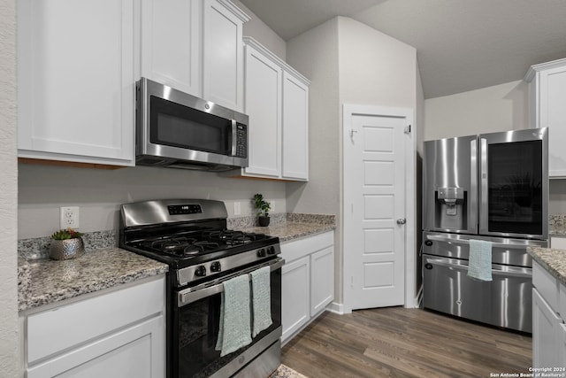 kitchen featuring white cabinets, appliances with stainless steel finishes, dark hardwood / wood-style flooring, and light stone counters