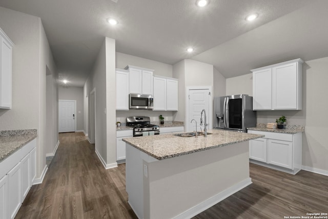 kitchen with sink, light stone counters, white cabinetry, and stainless steel appliances