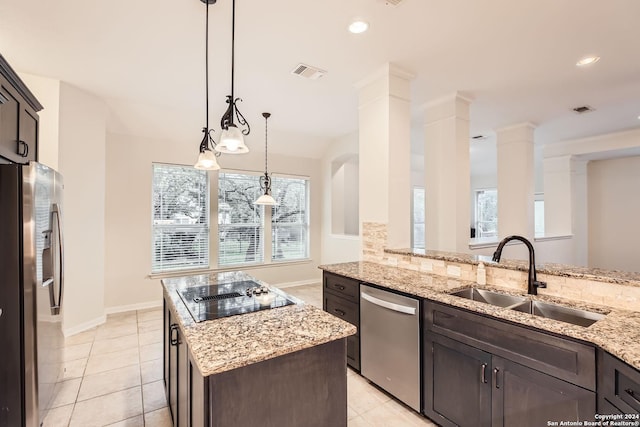 kitchen with light stone countertops, sink, stainless steel appliances, dark brown cabinets, and a kitchen island