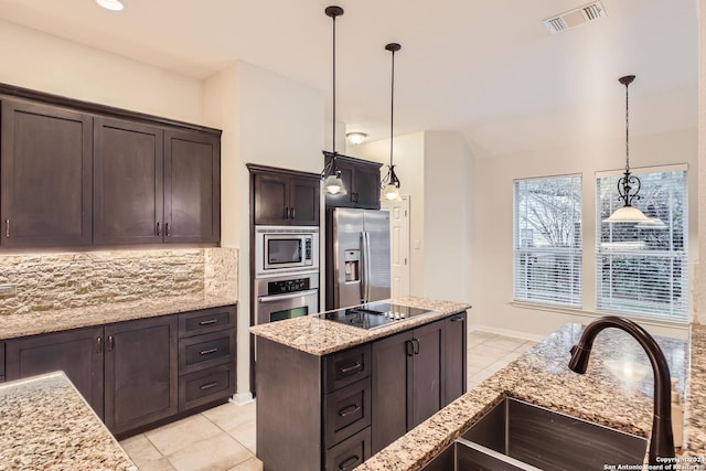 kitchen featuring pendant lighting, backsplash, sink, dark brown cabinetry, and stainless steel appliances